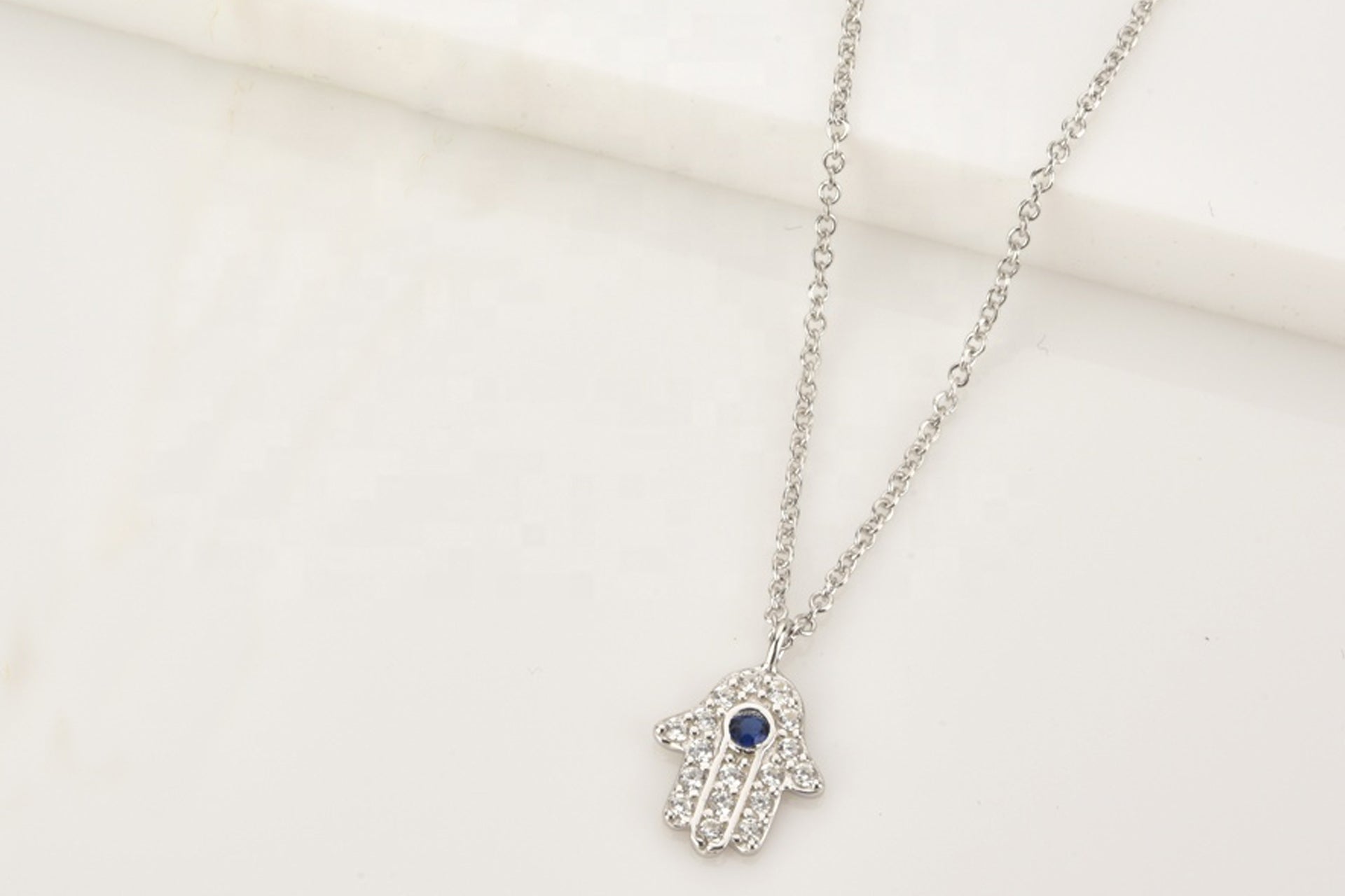 Platinum Plated Hamsa Necklace With Blue Cubic Zirconia and White Zirconia Embellishment Primal Chakra